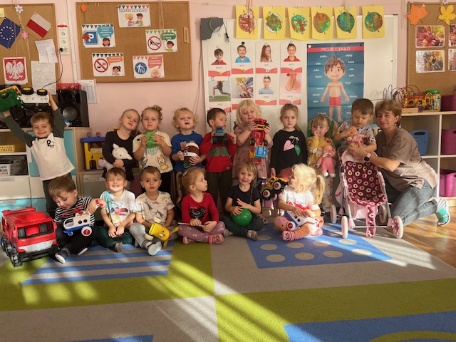  Dzieci siedzą na dywanie...